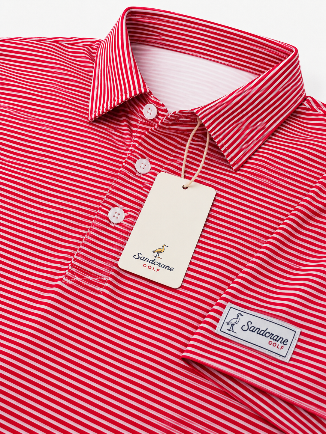 Red and white striped polo shirt with a white tag and a sewn-on brand patch from Sandorine Golf.