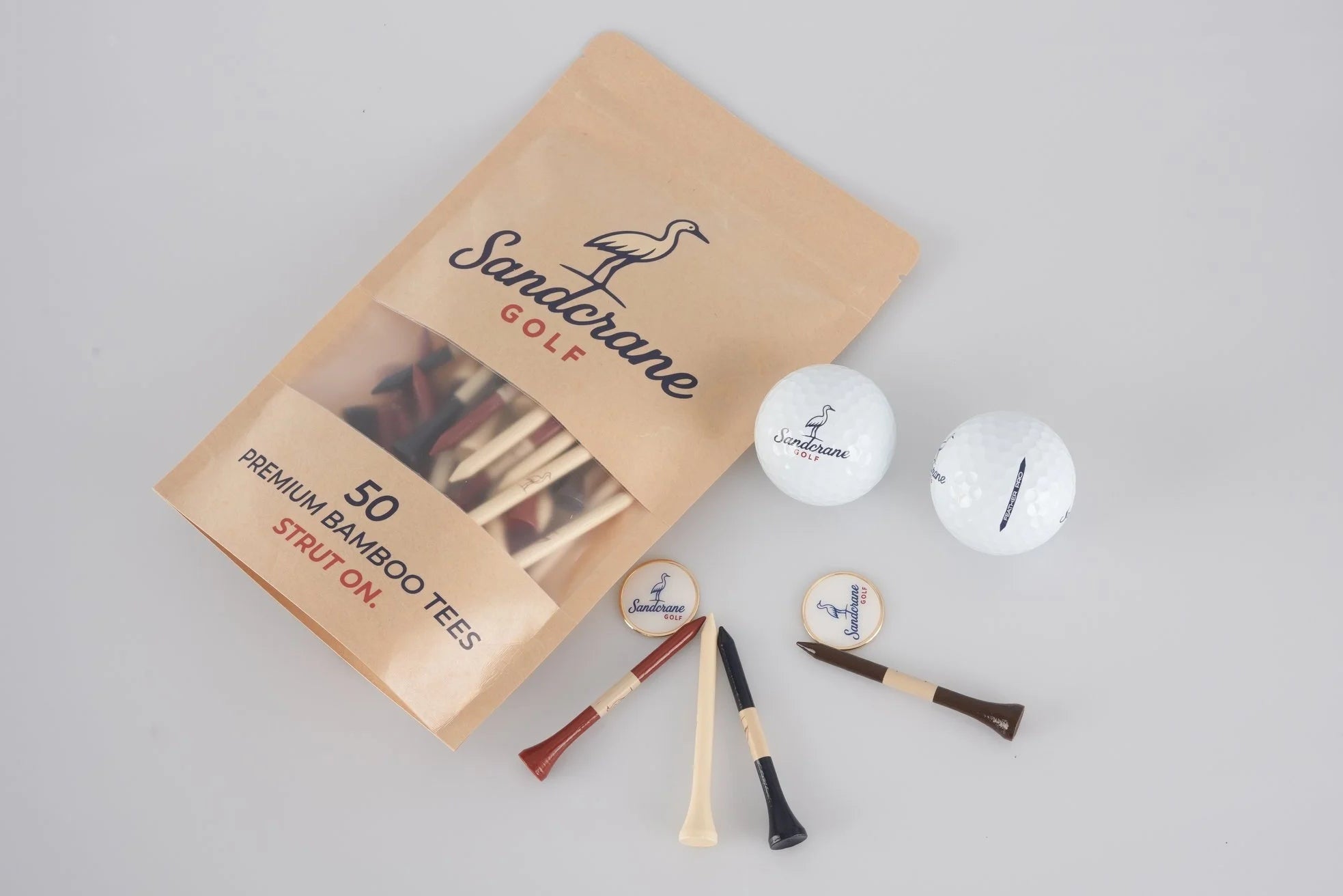 Golf packaging with golf tees and balls on a gray background